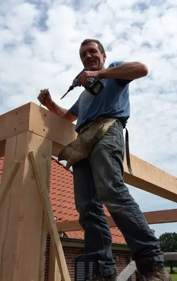 Rudie Geverinck aan het werk op een houten kapconstructie